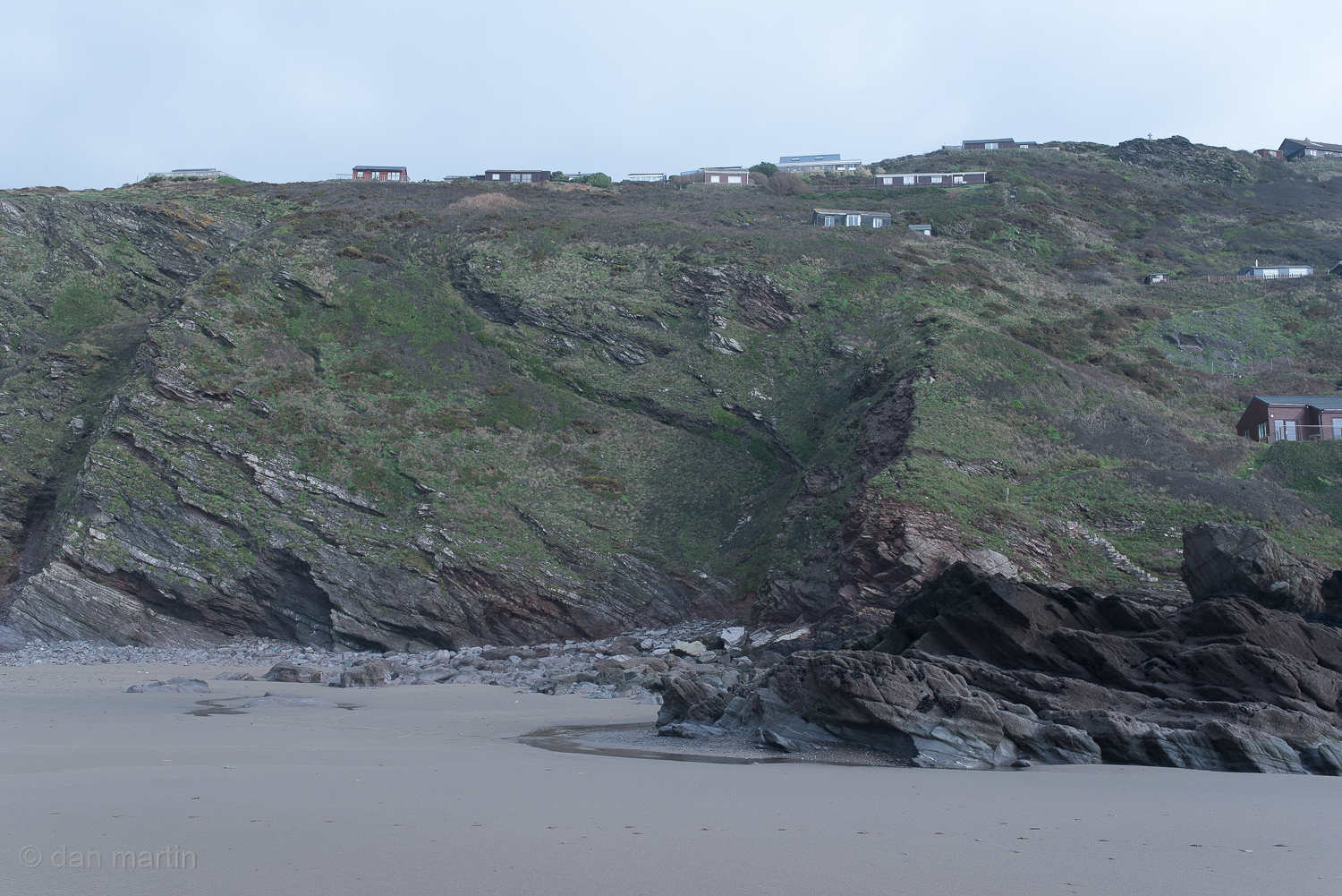I like the composition: the horizontal band of green. A sheer cliff face. The desaturated colours. You can imagine standing there. 