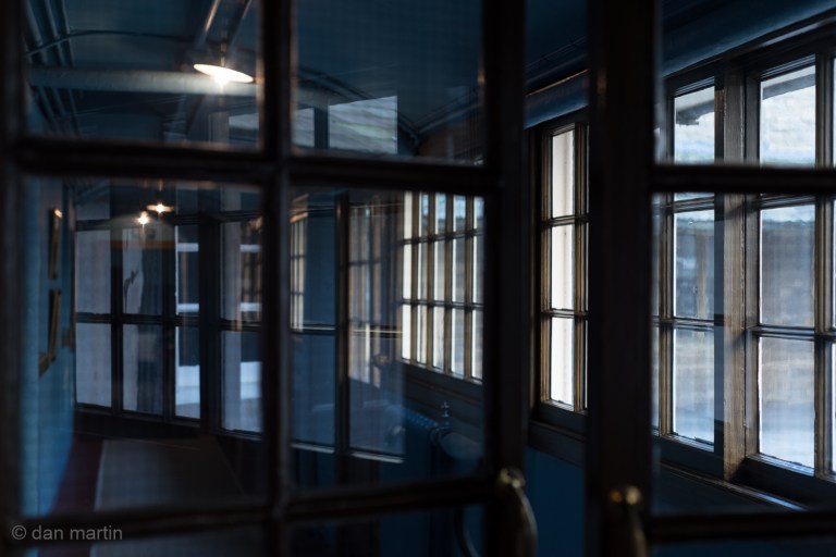 Sometimes something catches your eye. A different viewpoint  unintentionally discovered. If that door was at just a slightly different angle I would not have come across this; the layered reflections seemingly superimposed behind the  glass of the door. 