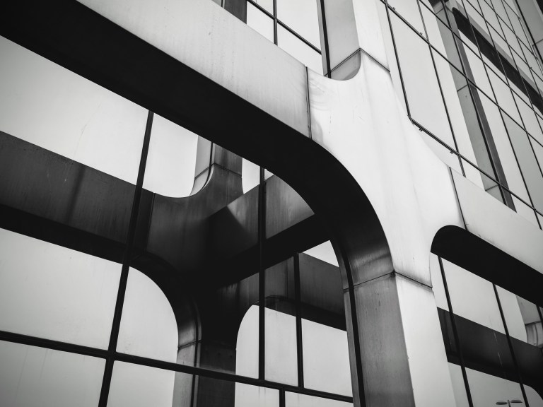 The glass facade of a building reflecting its outer structure.